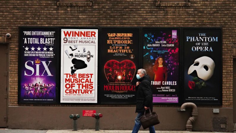 Una persona camina junto a los carteles de Broadway cerca de Times Square mientras los cines permanecen cerrados tras las restricciones impuestas para frenar la propagación del covid-19 el 15 de enero de 2021 en la ciudad de Nueva York (EE.UU.). (Cindy Ord/Getty Images)