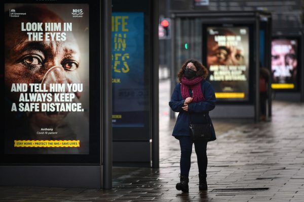 Un cartel del gobierno que recuerda a las personas que deben distanciarse socialmente y cumplir con las restricciones de cierre en Princess Street el 26 de enero de 2021 en Edimburgo, Escocia. (Foto de Jeff J Mitchell / Getty Images)