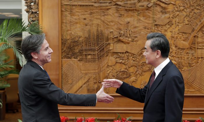 El subsecretario de Estado de Estados Unidos, Antony Blinken, le da la mano al ministro de Relaciones Exteriores de China, Wang Yi, en el Salón de los olivos  antes de una reunión en la oficina del Ministerio de Relaciones Exteriores, en Beijing, el 11 de febrero de 2015. (Andy Wong - Pool/Getty Images)
