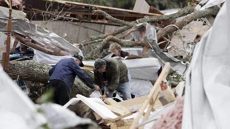 Miembros de la familia atraviesan los escombros de una casa móvil desde de un tornado el 3 de febrero de 2007 en Lake Lakes, Florida (EE.UU.). (Foto de Robert Sullivan / AFP a través de Getty Images)