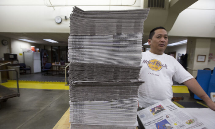 Un empleado empaqueta pilas de periódicos recién impresos en el periódico Columbian en Vancouver, Washington, el 18 de abril de 2018. (Natalie Behring/Getty Images)