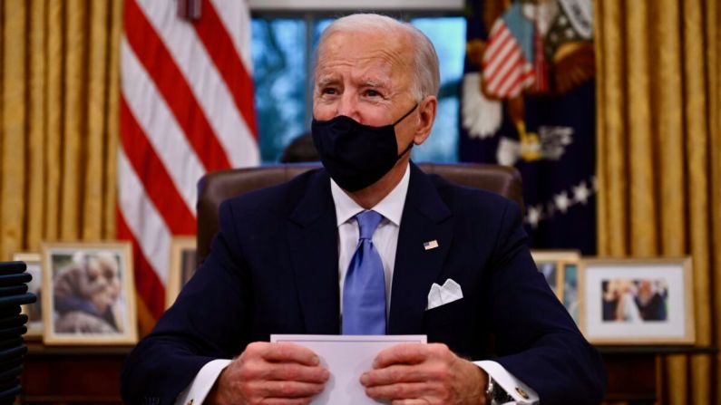 El presidente Joe Biden se prepara para firmar una serie de órdenes en la Oficina Oval de la Casa Blanca en Washington, el 20 de enero de 2021. (Jim Watson/AFP a través de Getty Images)