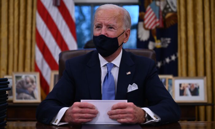 El presidente Joe Biden se prepara para firmar una serie de órdenes en el Despacho Oval de la Casa Blanca el 20 de enero de 2021. (Jim Watson/AFP a través de Getty Images)