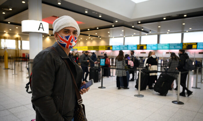 Un pasajero con una mascarilla con la bandera de Inglaterra espera para abordar uno de los pocos vuelos que salen del aeropuerto de Gatwick en Londres, el 27 de noviembre de 2020. (Leon Neal/Getty Images)