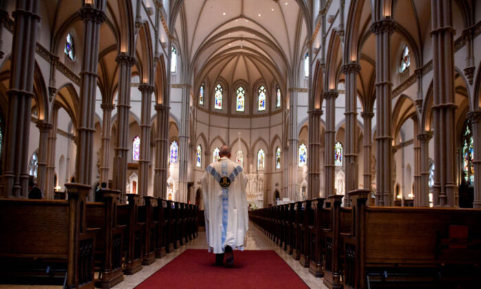 Un sacerdote camina hacia el santuario después de una misa en Pittsburgh, Pensilvania, el 15 de agosto de 2018. (Jeff Swensen/Getty Images)