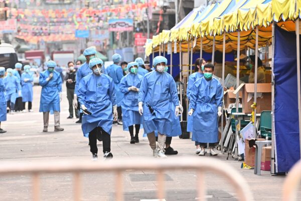 Trabajadores médicos caminan por Temple Street en el área de cierre, en el barrio Jordania, en Hong Kong, el 24 de enero de 2021. (Adrian Yu/The Epoch Times)
