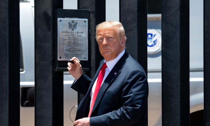 El presidente Donald Trump observa antes de firmar una placa mientras participa en una ceremonia que conmemora las 200 millas del muro fronterizo en la frontera internacional con México en San Luis, Arizona, el 23 de junio de 2020 (Saul Loeb / AFP a través de Getty Images).