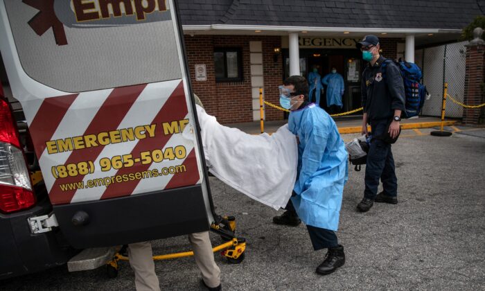 Un médico de Empress EMS carga a un paciente, sospechoso de COVID-19 del Centro de Cuidado Regency Extended, a una ambulancia en Yonkers, Nueva York, el 7 de abril de 2020. (John Moore/Getty Images)