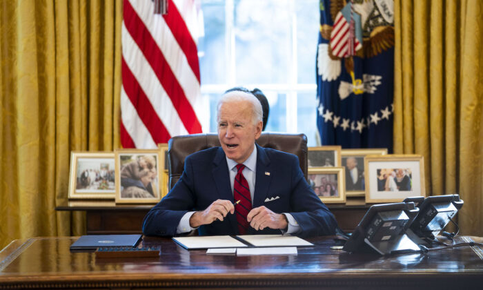 El presidente Joe Biden firma órdenes ejecutivas en el Despacho Oval de la Casa Blanca en Washington, el 28 de enero de 2021. (Doug Mills-Pool/Getty Images)