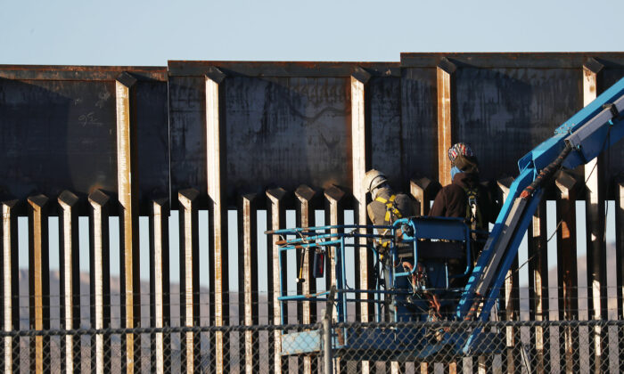 Personas trabajan en el muro fronterizo entre Estados Unidos y México en El Paso, Texas, el 12 de febrero de 2019. (Joe Raedle/Getty Images)
