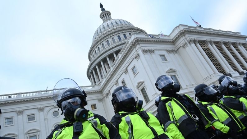 La policía permanece de pie mientras los partidarios del Presidente de EE.UU. Donald Trump protestan fuera del Capitolio de EE.UU. el 6 de enero de 2021, en Washington, DC. (BRENDAN SMIALOWSKI/AFP vía Getty Images)