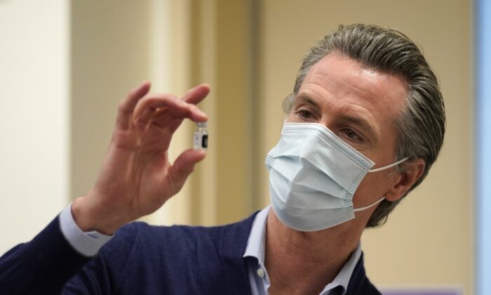 El gobernador de California, Gavin Newsom, sostiene un frasco de la nueva vacuna COVID-19 en el Centro Médico Kaiser Permanente de Los Ángeles, en Los Ángeles, California, el 14 de diciembre de 2020. (Jae C. Hong/Pool/Getty Images)