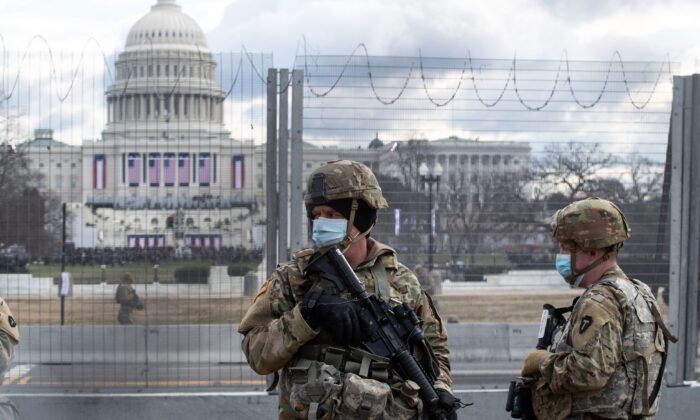 Tropas de la Guardia Nacional de EE.UU. patrullan los alrededores del Capitolio de EE.UU. horas antes de la toma de posesión del presidente electo Joe Biden en Washington el 20 de enero de 2021. (Roberto Schmidt/AFP vía Getty Images)