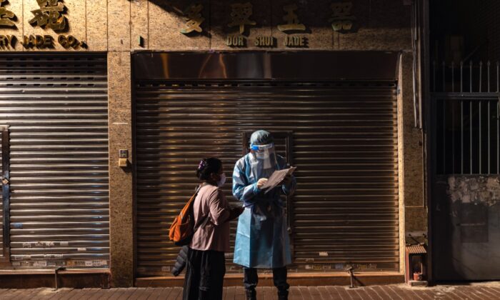 Un trabajador de la salud habla con un residente en un sitio de pruebas temporal donde se confirmaron casos de COVID-19 en el distrito de Jordan en Hong Kong, el 20 de enero de 2021. (Anthony Kwan/Getty Images)