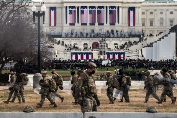 Tropas de la Guardia Nacional con escudos antidisturbios caminan mientras asumen posiciones en las cercanías del Capitolio de EE. UU. para la inauguración de Joe Biden en Washington, el 20 de enero de 2021. (Roberto Schmidt/AFP a través de Getty Images)