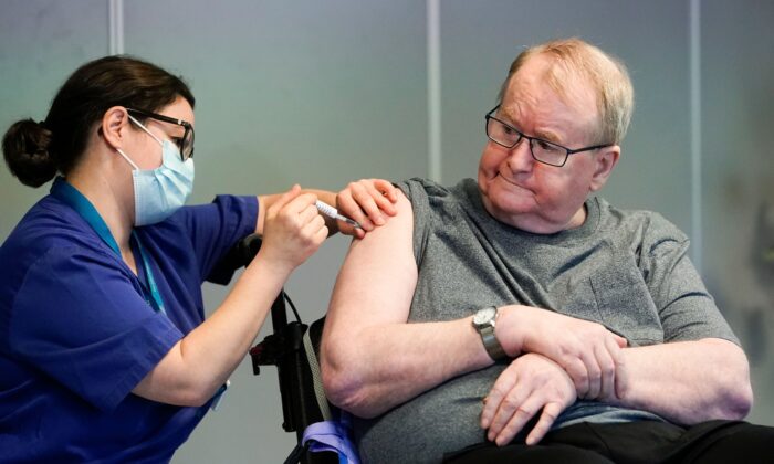 Svein Andersen, de 67 años, residente en el "Hogar Ellingsrud" y el primero en Noruega en recibir la vacuna Pfizer-Biontech Covid-19 de la enfermera Maria Golding en Oslo, el 27 de diciembre de 2020. (Fredrik Hagen/NTB/AFP vía Getty Images)