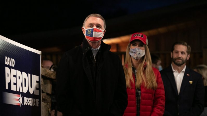 Los senadores David Perdue (R-Ga.), izquierda, y Kelly Loeffler (R-Ga.) de pie durante un rally en Cumming, Ga., el 20 de diciembre de 2020. (Jessica McGowan/Getty Images)
