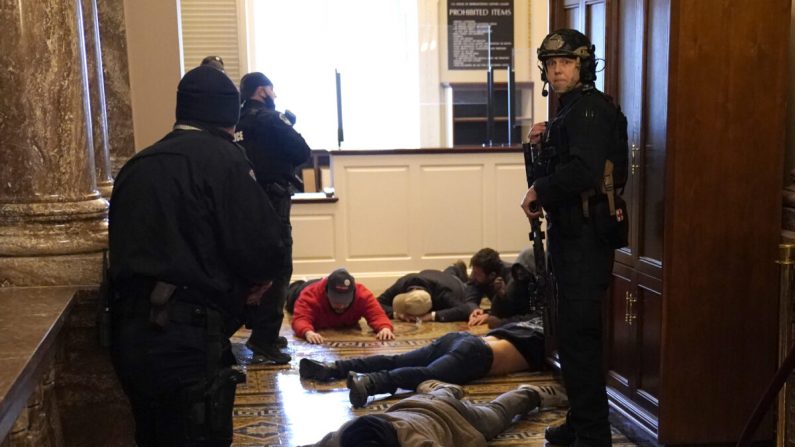 La policía del Capitolio de EE.UU. detiene a las personas que entraron en el edificio del Capitolio de EE.UU. en Washington el 6 de enero de 2021. (Drew Angerer/Getty Images)