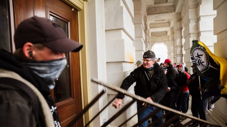 Los manifestantes irrumpen una entrada del edificio del Capitolio en Washington el 6 de enero de 2021. (Jon Cherry/Getty Images)