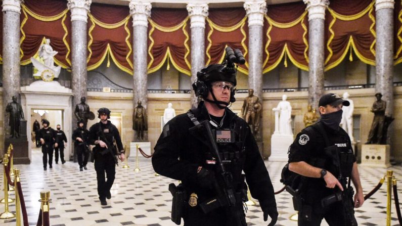 Miembros del equipo Swat patrullan y aseguran la Sala de Estatuas antes de que el vicepresidente Mike Pence entre en la Cámara de Representantes, en el Capitolio de EE. UU. en Washington, el 7 de enero de 2021. (Olivier Douliery/AFP vía Getty Images)