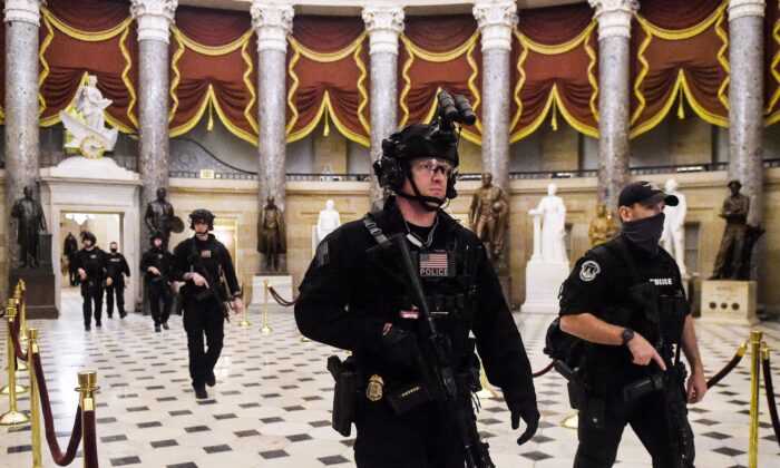 Miembros del equipo Swat patrullan y aseguran la Sala de Estatuas antes de que el vicepresidente Mike Pence entre en la Cámara de Representantes, en el Capitolio de EE.UU. en Washington el 7 de enero de 2021. (Olivier Douliery/AFP vía Getty Images)