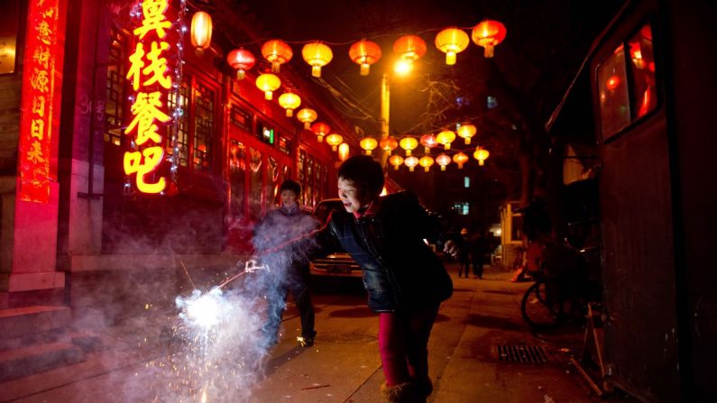 Una niña sostiene un petardo en un callejón de Beijing durante el Festival de las Linternas, que marca el final de las celebraciones del período del Año Nuevo chino. (Ed Jones/AFP/Getty Images)
