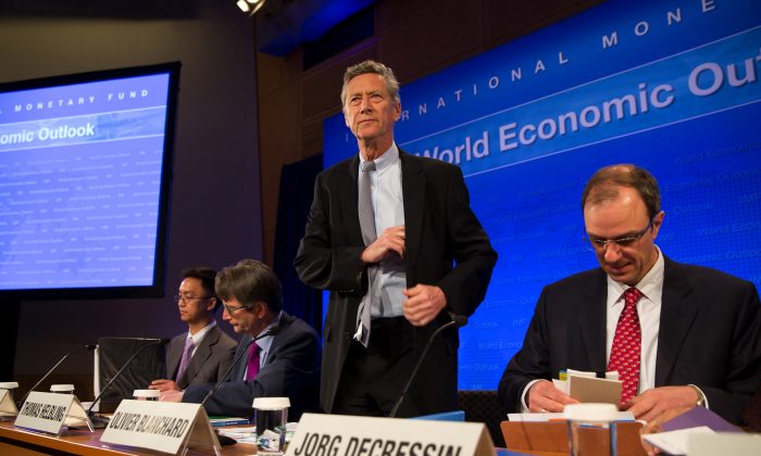 Olivier Blanchard (de pie) en una conferencia de prensa conjunta sobre perspectivas de la economía mundial en la sede del FMI, en Washington, el 16 de abril de 2013. (Stephen Jaffe/FMI a través de Getty Images)