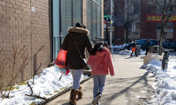Una mujer y una niña caminan por la calle en Flushing, Nueva York, el 10 de febrero de 2021. (Chung I Ho/The Epoch Times)
