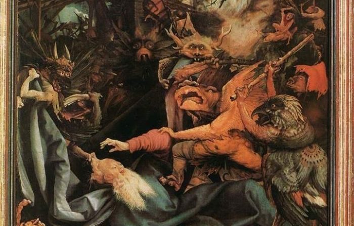 Antonio es asediado por demonios que le atacan con palos a la derecha de la composición y, a la izquierda, otros le tiran del manto y del cabello, en un detalle de "La tentación de San Antonio" de Mathias Grünewald. (Dominio público)