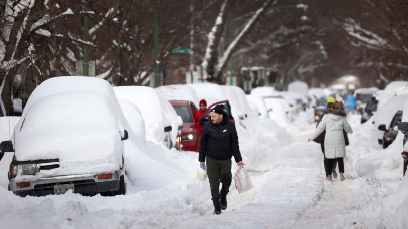 La gente camina por una calle cubierta de nieve el 16 de febrero de 2021 en Chicago, Illinois (EE.UU.). (Foto de Scott Olson / Getty Images)