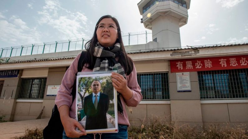 Esta foto tomada el 30 de octubre de 2019 muestra a Xu Yan, esposa del abogado de derechos humanos Yu Wensheng, sostiene la foto de Yu frente al centro de detención de la ciudad de Xuzhou (China), después de que fue detenido el año pasado. (Nicolas Asfouri / AFP vía Getty Images)