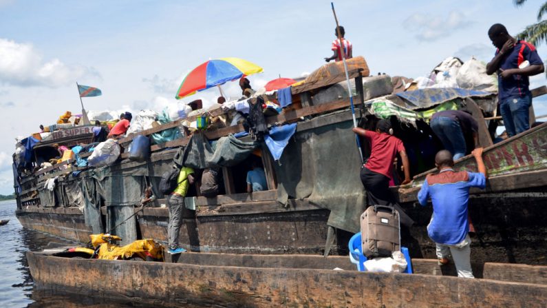 Pasajeros y comerciantes se embarcan en una barcaza en el río Congo, en Mbandaka, en el norte de la República Democrática del Congo, el 9 de septiembre de 2018. (Foto de Junior Kannah / AFP a través de Getty Images)