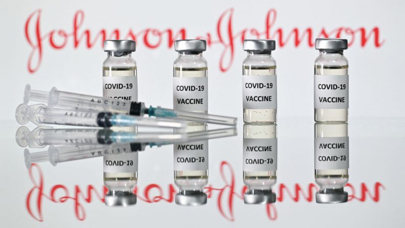 Una ilustración muestra frascos con adhesivos de vacuna contra el covid-19 adheridos y jeringas con el logotipo de la compañía farmacéutica estadounidense Johnson & Johnson el 17 de noviembre de 2020. (Foto de Justin Tallis / AFP a través de Getty Images)