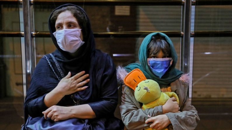 Los iraníes que usan mascarillas contra el covid-19 se reúnen frente a sus edificios después de que se sintiera un terremoto en la capital, Teherán, el 7 de mayo de 2020. (Foto de Amir Kholousi / ISNA NEWS AGENCY / AFP a través de Getty Images)