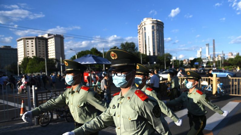 Policías paramilitares patrullan a lo largo de una calle después de la sesión de clausura de la Conferencia Consultiva Política del Pueblo Chino (CCPPCh) en Beijing el 27 de mayo de 2020. (Greg Baker/AFP vía Getty Images)
