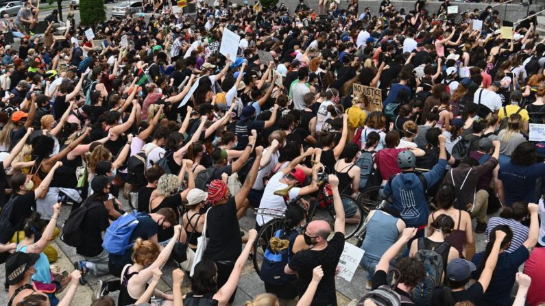 Manifestantes se arrodillan y levantan los puños durante una manifestación de "Black Lives Matter" frente a la Biblioteca de Brooklyn y Grand Army Plaza en Brooklyn, NY, el 5 de junio de 2020. (Angela Weiss/AFP a través de Getty Images)