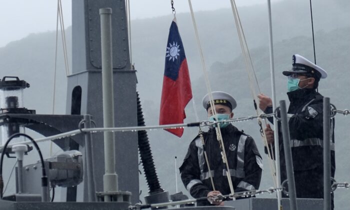 Dos soldados de la marina izan la bandera nacional de Taiwán durante una ceremonia oficial en un astillero en Su'ao, un municipio del Condado de Yilan, al este de Taiwán, el 15 de diciembre de 2020. (Sam Yeh/AFP vía Getty Images)