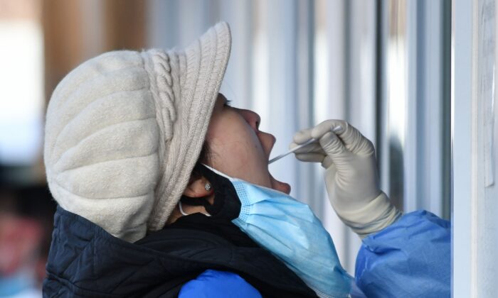 Una mujer se somete al test de COVID-19 en el exterior de un hospital de Beijing (China) el 28 de enero de 2021. (GREG BAKER/AFP vía Getty Images)