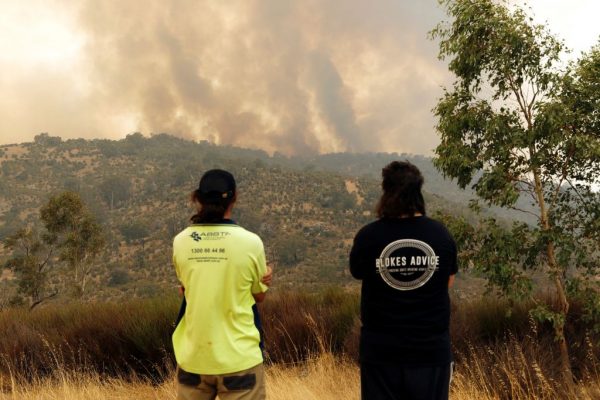 La gente ve cómo un incendio impulsado por fuertes vientos arde en una cresta en el suburbio de Brigadoon en Perth, Australia, el 2 de febrero de 2021. (Foto de Trevor Collens / AFP a través de Getty Images)