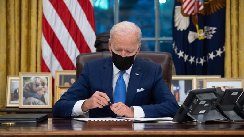 El presidente Joe Biden firma órdenes ejecutivas relacionadas con la inmigración en la Oficina Oval de la Casa Blanca en Washington el 2 de febrero de 2021. (SAUL LOEB/AFP a través de Getty Images)
