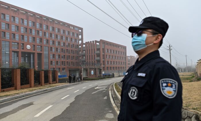 Un agente de seguridad hace guardia mientras los miembros del equipo de la Organización Mundial de la Salud (OMS) que investigan los orígenes del COVID-19 realizan una visita al Instituto de Virología de Wuhan, en Wuhan, en la provincia central china de Hubei, el 3 de febrero de 2021. (HECTOR RETAMAL/AFP a través de Getty Images)
