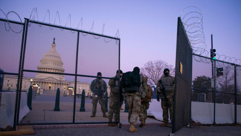 Miembros de la Guardia Nacional ingresan por una puerta de alambre de púas en los terrenos del Capitolio de Estados Unidos, al amanecer el 8 de febrero de 2021, en Washington, D.C. (Sarah Silbiger/Getty Images)