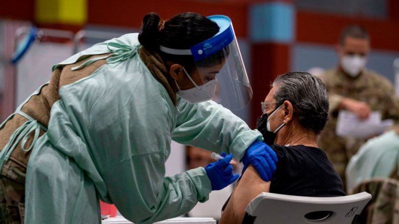 Una trabajadora de la salud aplica una inyección de la vacuna en un centro de vacunación de la Guardia Nacional de Puerto Rico durante un programa de vacunación prioritaria contra el covid-19 para ancianos, en San Juan, Puerto Rico, el 8 de febrero de 2021. (Ricardo Arduengo / AFP vía Getty Images)