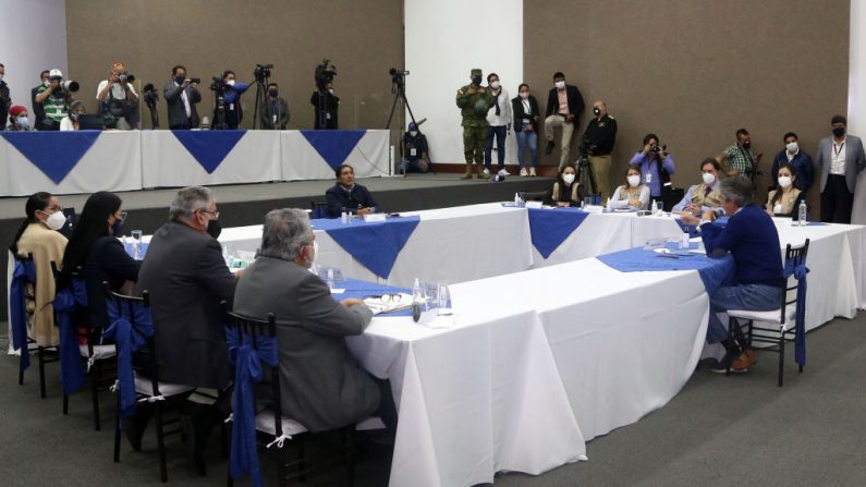 Los candidatos presidenciales ecuatorianos Guillermo Lasso (d) y Yaku Pérez (c) se enfrentan durante una reunión en el Consejo Nacional Electoral (CNE), acompañados por miembros del CNE y la OEA, en Quito (Ecuador), el 12 de febrero de 2021. (Foto de Cristina Vega Rhor / AFP a través de Getty Images)