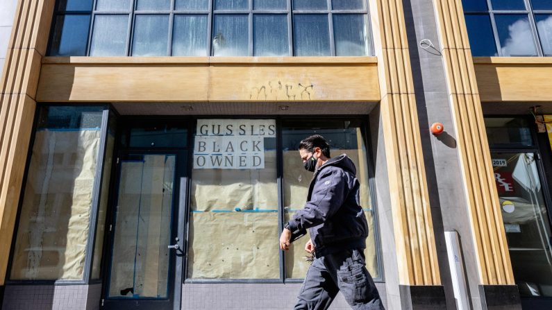 Una persona pasa junto a una tienda cerrada en la ventana en Oakland, California, el 12 de febrero de 2021. (JOSH EDELSON/AFP a través de Getty Images)