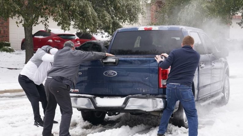 Residentes ayudan a un conductor a sacar su pickup del hielo en la carretera en Round Rock, Texas, el 17 de febrero de 2021, luego de una tormenta de invierno. (SUZANNE CORDEIRO/AFP a través de Getty Images)