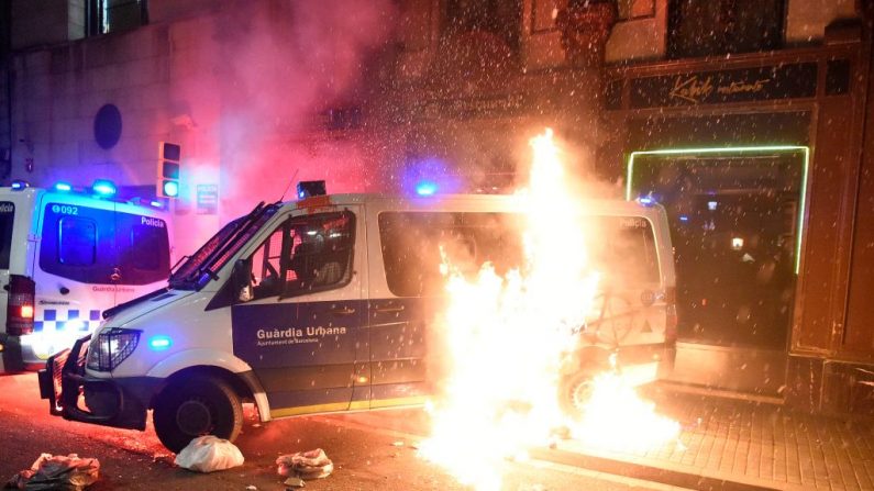Un cóctel Molotov estalla en llamas junto a un vehículo de la Policía Municipal durante una manifestación por diversos temas sociales bajo el lema "Lucha, Crea Poder Popular" en Barcelona, España, el 27 de febrero de 2021. (Josep Lago / AFP a través de Getty Images)