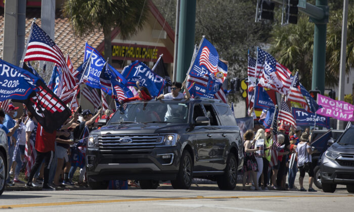 Simpatizantes del expresidente Donald Trump se reúnen a lo largo de Southern Boulevard cerca de la casa de Trump en Mar-a-Lago en West Palm Beach, Florida, el 15 de febrero de 2021. (Joe Raedle/Getty Images)