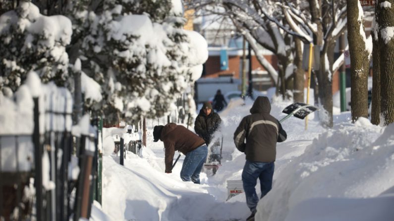 Los residentes limpian la nieve de una acera el 16 de febrero de 2021 en Chicago, Illinois (EE.UU.). (Foto de Scott Olson / Getty Images)