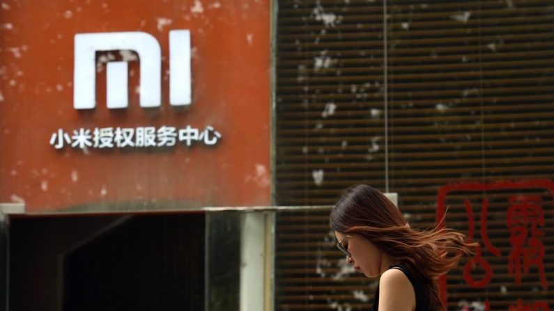Una persona pasa junto a un logotipo de Xiaomi frente a un centro de servicios de Xiaomi, en Beijing (China), el 5 de agosto de 2015. (Greg Baker/AFP vía Getty Images)
